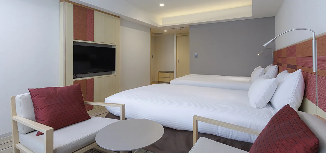 JR Kyushu Hotel Blossom Hakata Chuo Deluxe Twin의 주침대와 3인용 트런들베드